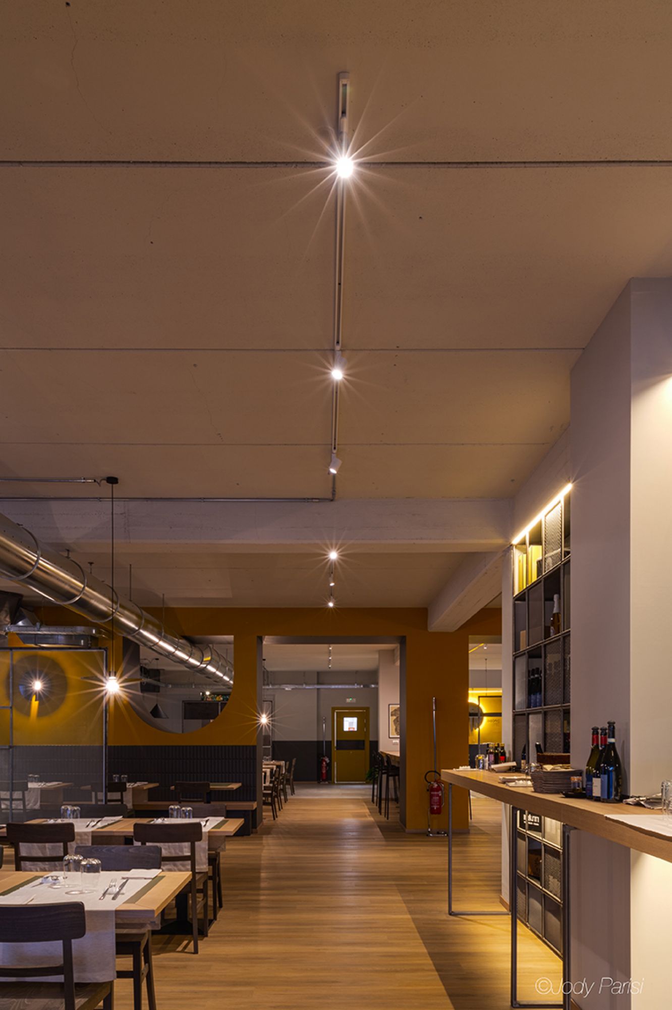 Sala ristorante illuminata con faretti da soffitto e luci a sospensione